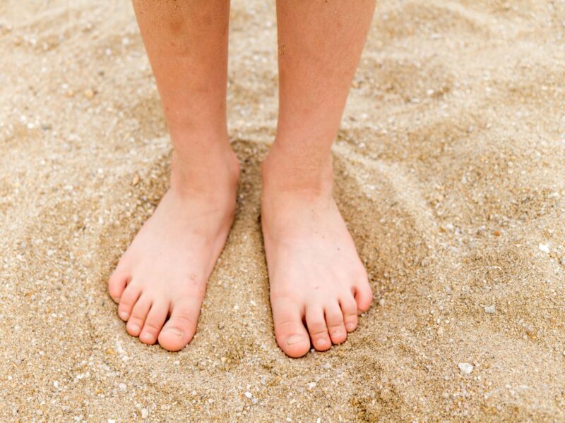 Child's flat feet on sand