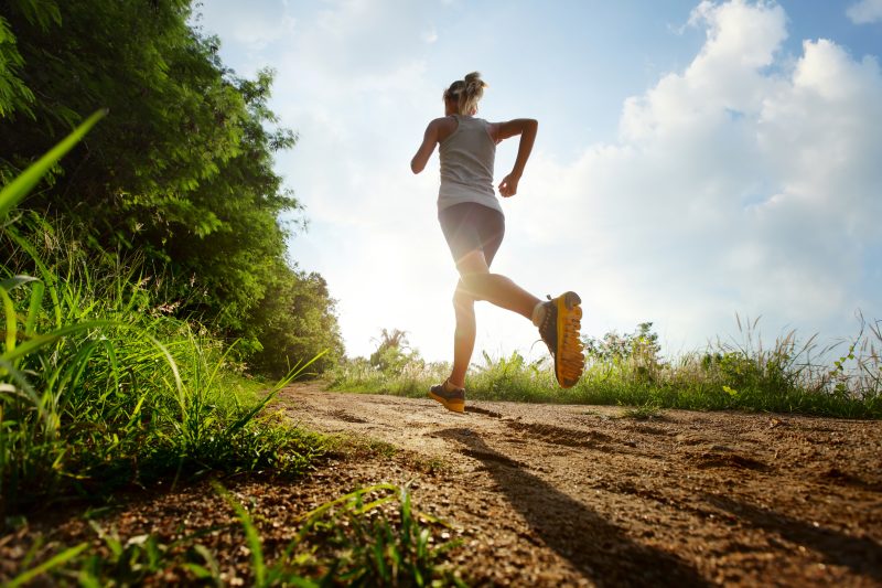 Young,Lady,Running,On,A,Rural,Road,During,Sunset