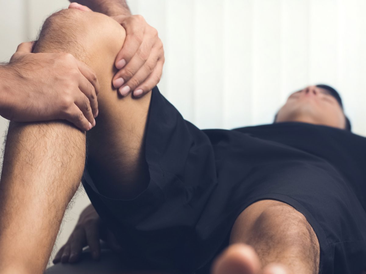 Therapist,Treating,Injured,Knee,Of,Athlete,Male,Patient, ,Sport