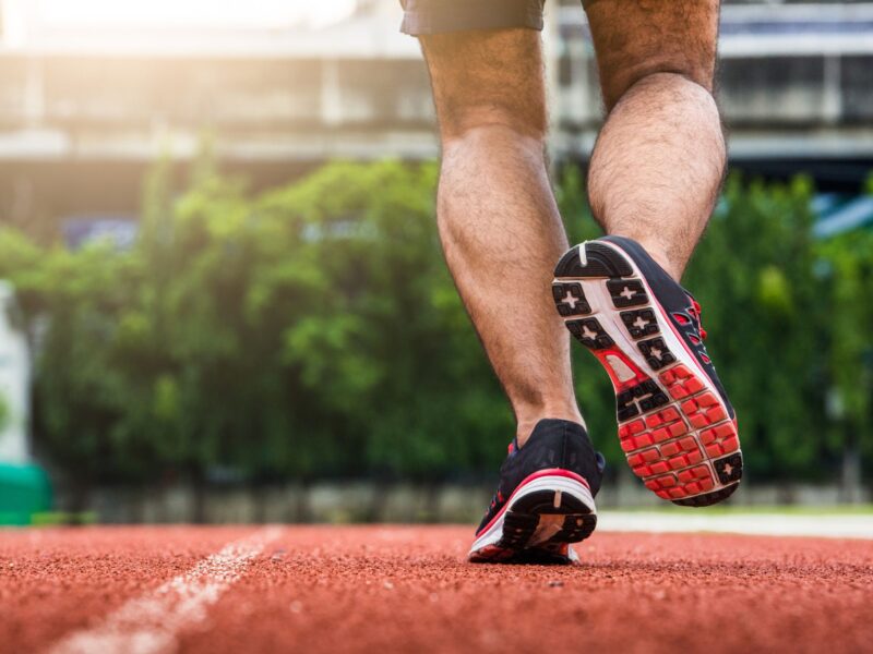 Legs of a man running on a running track